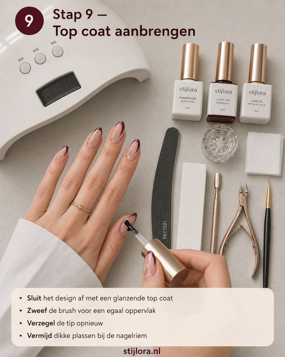 Glanzende top coat aanbrengen om de bordeaux nagels met goud swirl mooi af te sluiten