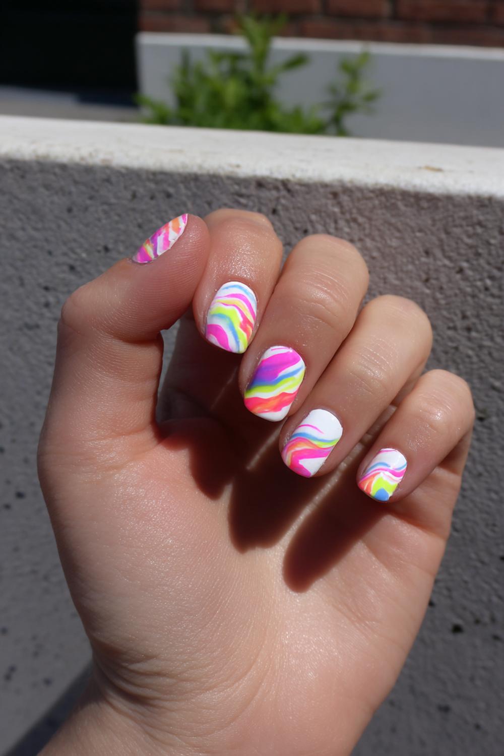 15. Carnaval nagels met regenboogswirls en witte highlights