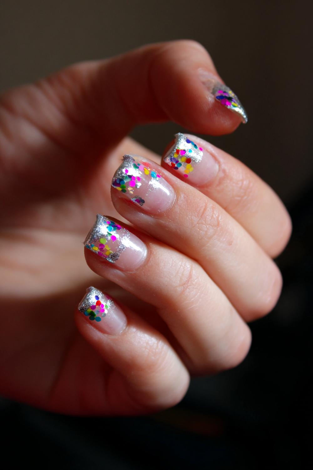 38. Carnaval nagels met regenboog confetti en zilveren outline