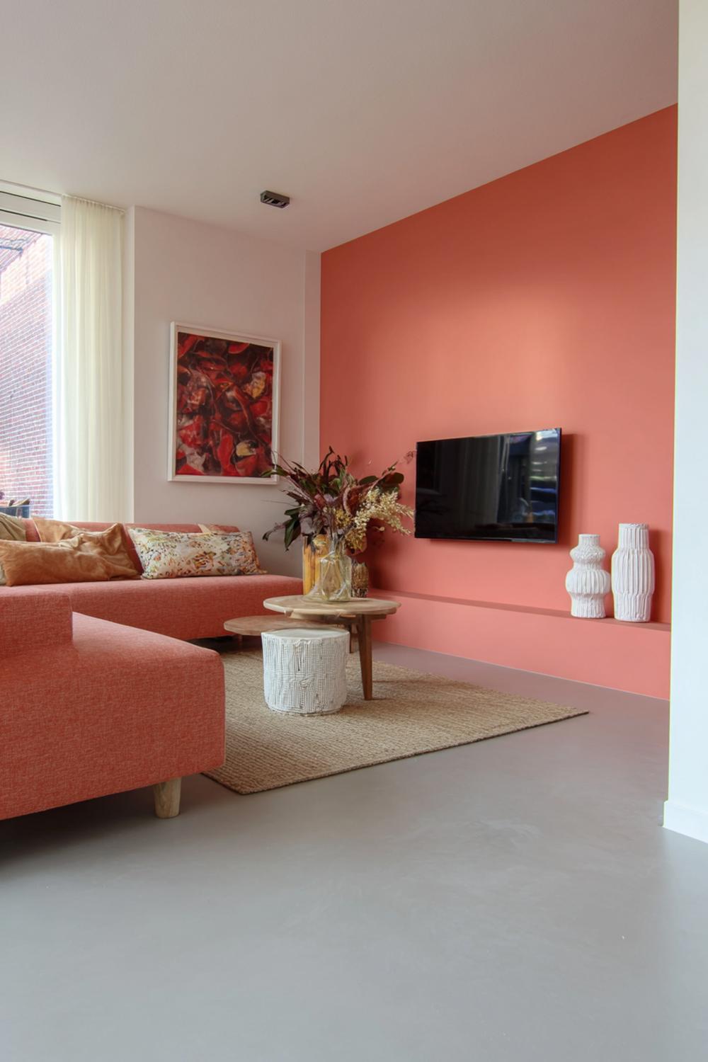 13. Kleurrijke woonkamers met koraalrode kunstwand en betonlook vloer