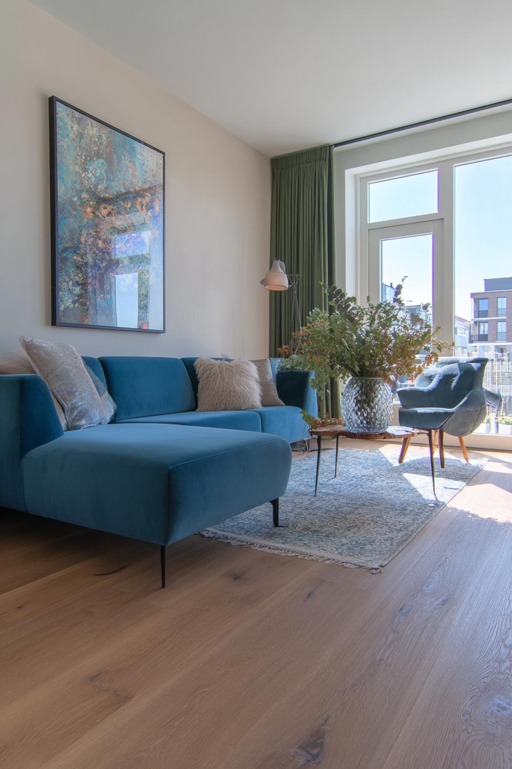 28. Kleurrijke woonkamers met ultramarijn kunstwerk en houten vloer