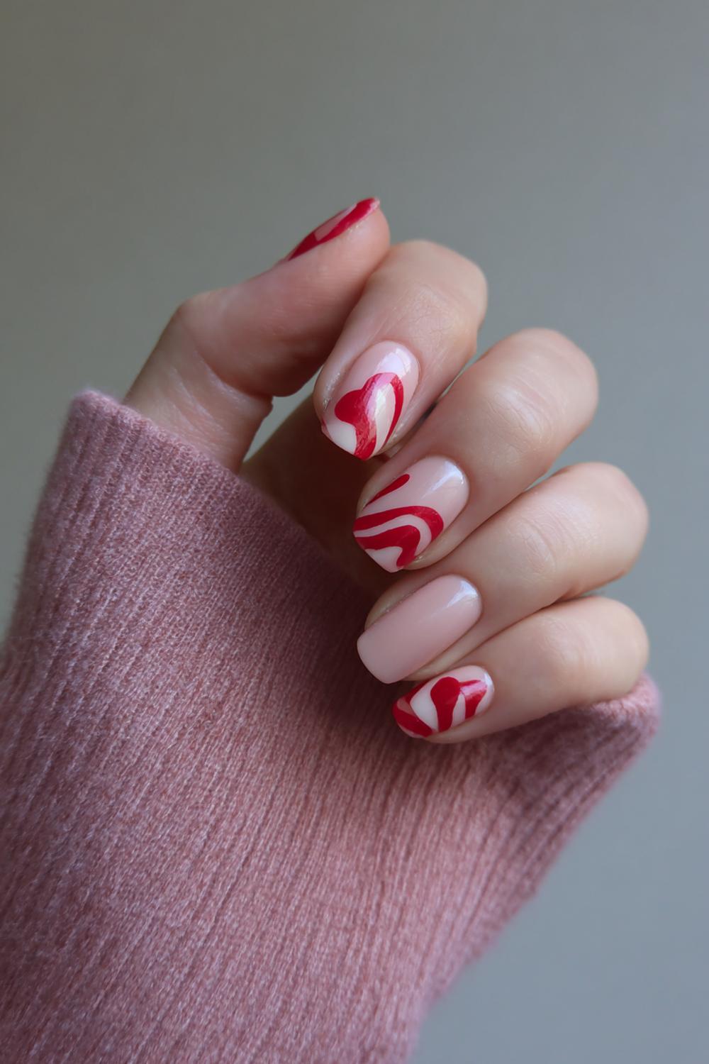 22. Nagels valentijn met rood ‘swirl’ patroon op melkachtig nude