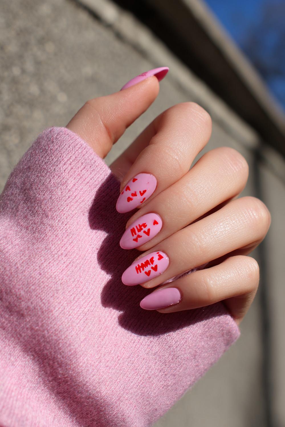 32. Nagels valentijn met roze ‘milky’ basis en rood letterdetail