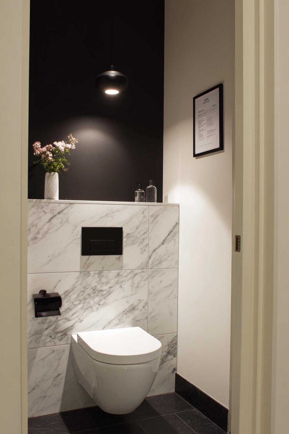 24. Toilet inspiratie met zwarte accentwand en wit sanitair contrast