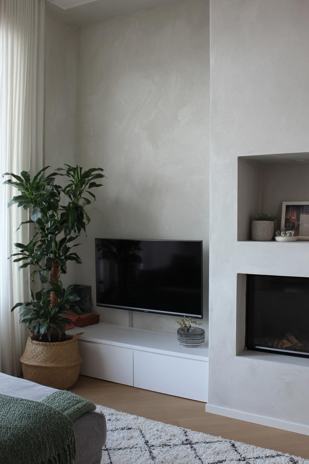 16. Tv wand ontwerp met minimalistische microcement wand en nisplank
